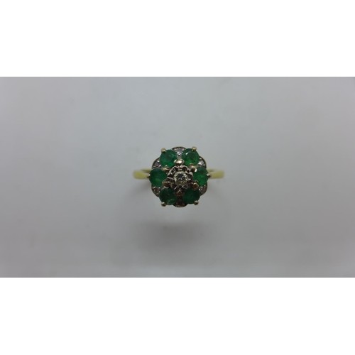An 18ct gold emerald and diamond cluster ring with an illusi...