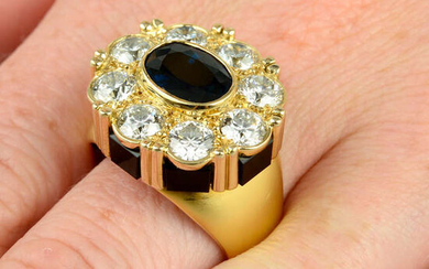 An 18ct gold sapphire and brilliant-cut diamond cluster ring, with onyx panel gallery.