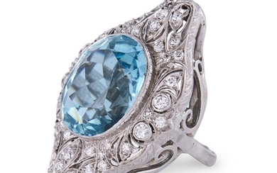An aquamarine, diamond, and platinum ring centering an oval-cut...