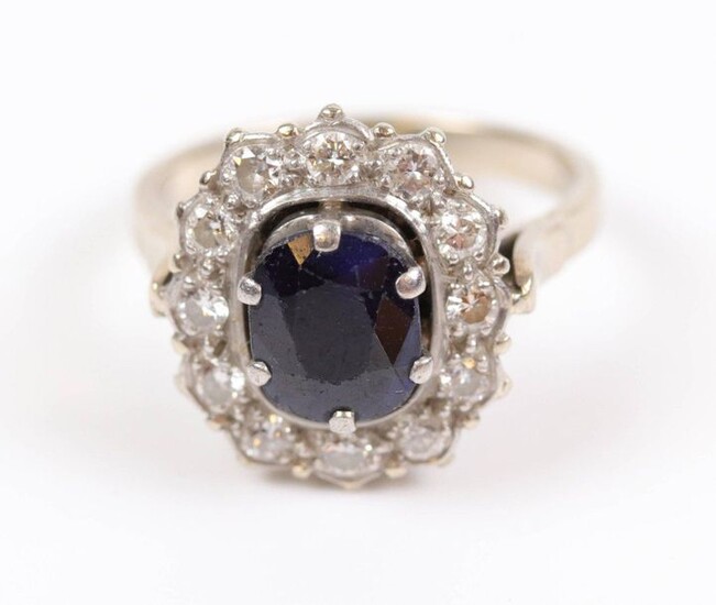 Daisy ring, sapphire centre set in a closed setting (for about 1.5 ct), in a setting of 12 small brilliants, set in white gold (750) and platinum (950). T: 55 cm, Weight: 6.2 gr.