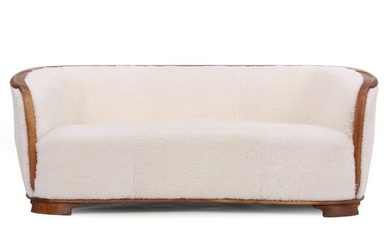 Danish cabinetmaker: Sofa with oak frame in a slightly curved shape. Upholstered with light coloured sheepskin. H. 73 cm. L. 187 cm. D. 83 cm.