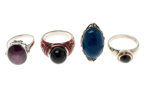 FOUR SILVER STONE SET RINGS; one set with an approx. 21ct star ruby, one with an onyx bead to red enamel shoulders, one with a star...