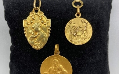 Lot en or jaune 18K (750/oo) comprenant trois médailles religieuses, une Eucharistie, une Vierge à...