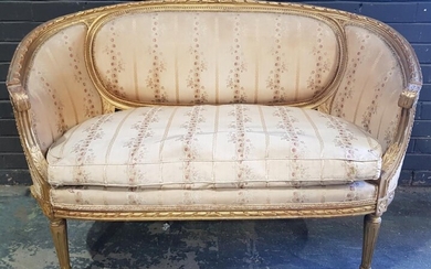Louis XVI Style Carved Gilt Settee or Canape, of curved form, upholstred in a striped floral silk fabric (slight wear) & on turned r...