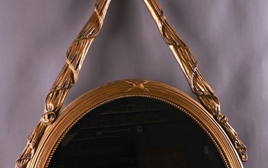 Miroir ovale doré de style Louis XVI.