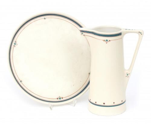A matt white glazed ceramic milk pitcher with serving tray, both with linear pattern, both marked F.H., the tray additionally with number 1008. (2)