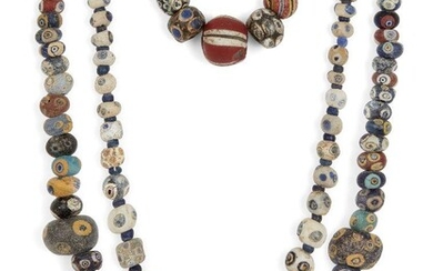 Two Eastern Mediterranean 'eye' bead necklaces Circa 5th-3rd Century B.C. and Later A necklace composed of polychrome spherical 'eye' beads of varying size, 53.5cm; another of white beads with blue eyes, 46.5cm and a string of sixteen 'eye' beads...
