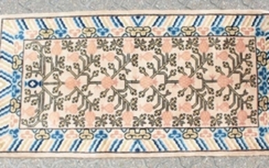 A CHINESE WOOL RUG with central motifs and blue and