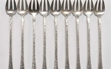 NINE TIFFANY & CO. ACID-ETCHED "LAP-OVER-EDGE" PATTERN STERLING SILVER OYSTER FORKS Each with a different seashell design extending...