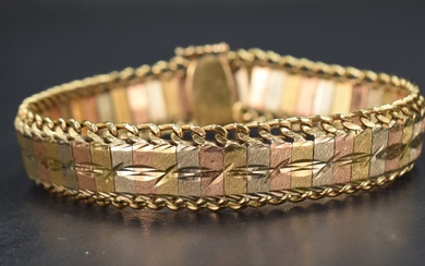 A 1980's three coloured yellow metal articulated bracelet having brushed and cut panels with a
