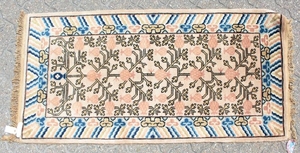A CHINESE WOOL RUG with central motifs and blue and