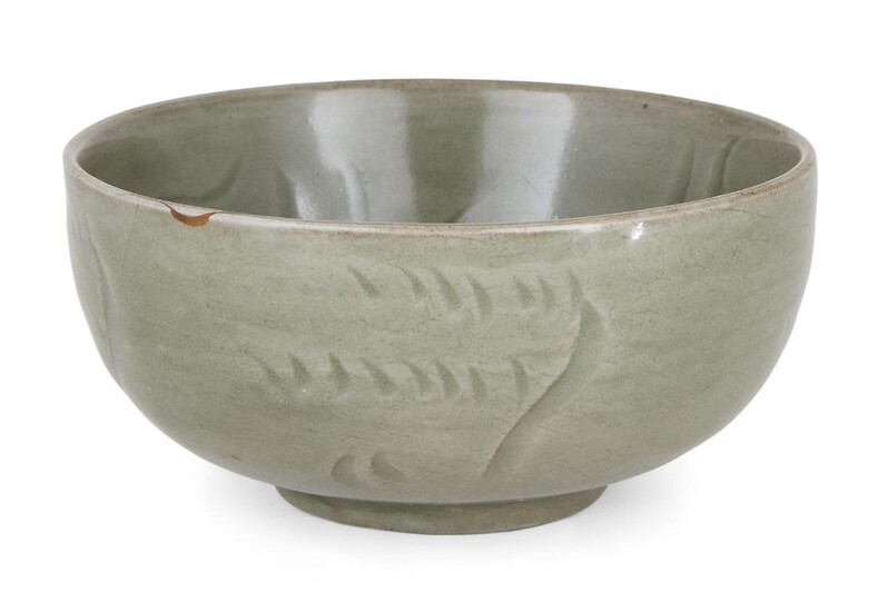 A Chinese Longquan celadon 'lotus' bowl, Ming dynasty, the interior decorated with an incised lotus blossom amongst wavy flourishes, the exterior with further incised abstract decoration, covered in an allover celadon glaze, 14cm diameter...