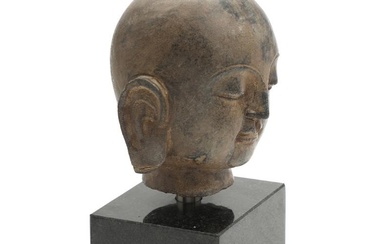 A Chinese carved stone head of Buddha. Raised on a more recent...