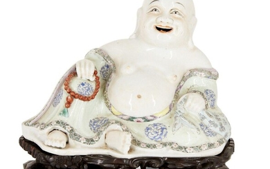 A Chinese porcelain famille rose figure of Budai, Qianlong period, modelled in a relaxed pose and laughing, dressed in pale green robes decorated with chilong medallions, the hem with flowering lotus blossoms and daisies, holding a necklace in his...