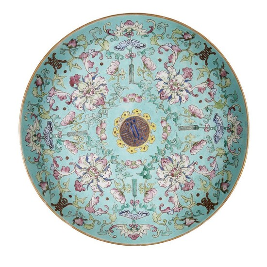 A Chinese porcelain 'sanduo' dish, 19th century, painted in famille rose enamels on a turquoise ground with lotus blooms and meandering leafy scrolls interspersed with bats and Buddhist chimes, all encircling a central shou character, the underside...