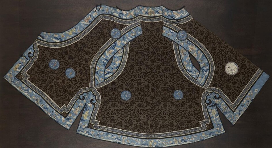 A Chinese silk embroidered ladies robe, late 19th century, decorated with Buddhist emblems and floral sprays on a brown ground with blue trim decorated with figures and floral sprays, 83cm long, in glazed frame