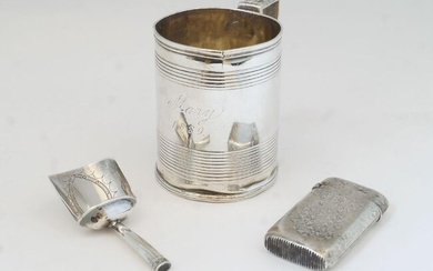 A George III silver cup, London, 1819, makers marks rubbed, with banded decoration and acanthus handle, engraved Mary 1889, 7cm high; together with a George III tea caddy scoop, Birmingham, 1802, John Thornton, 7cm long; and a French vesta case...