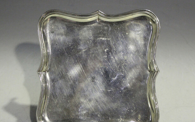 A George V silver card salver of shaped square form, raised on angular reeded legs, London 1933 by W