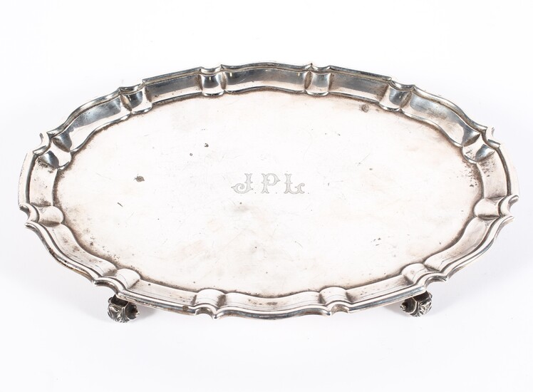 A George V silver footed salver of oval form with pie crust border