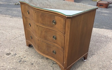 A Georgian style mahogany serpentine fronted chest of drawers with...
