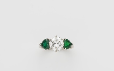 A German 18k gold emerald and diamond solitaire three stone ring.