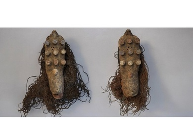 A PAIR OF AFRICAN CARVED WOODEN GREBO MASKS Having nine prot...