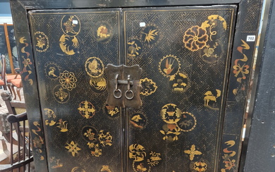 A PAIR OF CHINESE BLACK LACQUERED CABINETS, THE DOORS GILT WITH ROUNDELS ON A GEOMETRIC GROUND AND