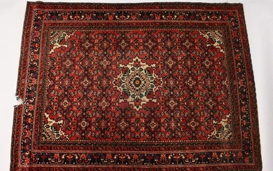 A PERSIAN RUG, 20TH CENTURY, red ground with central