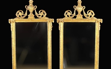 A Pair of Louis XVI Style Gilt Wall Mirrors. The rectangular glass panels in moulded frames decorate
