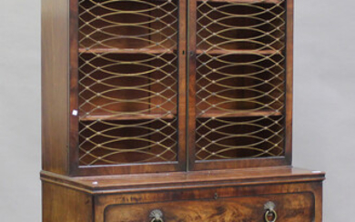 A Regency figured mahogany secrétaire bookcase cabinet, the top with two doors inset with gilt