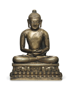 A SILVER- AND COPPER-INLAID BRONZE FIGURE OF A BUDDHA, WESTERN TIBET, 11TH-12TH CENTURY