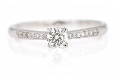 NOT SOLD. A diamond ring set with a brilliant-cut diamond flanked by numerous diamonds weighing...