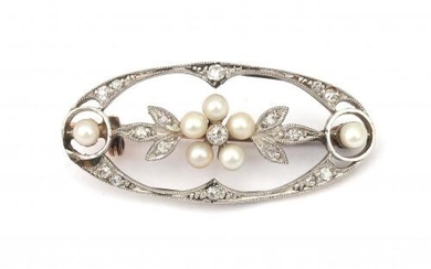 A gold Belle Epoque diamond and pearl brooch. In the center a cluster of seed pearls as flower surrounded by a border of foliage set with single cut diamonds. The gold was found below the Dutch legal gold grade of 14 karat. Gross weight: 3.3 g.