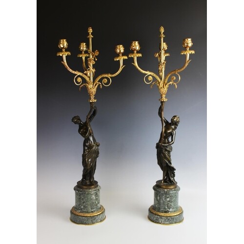 A pair of bronze and gilt metal figural candlesticks, 19th c...