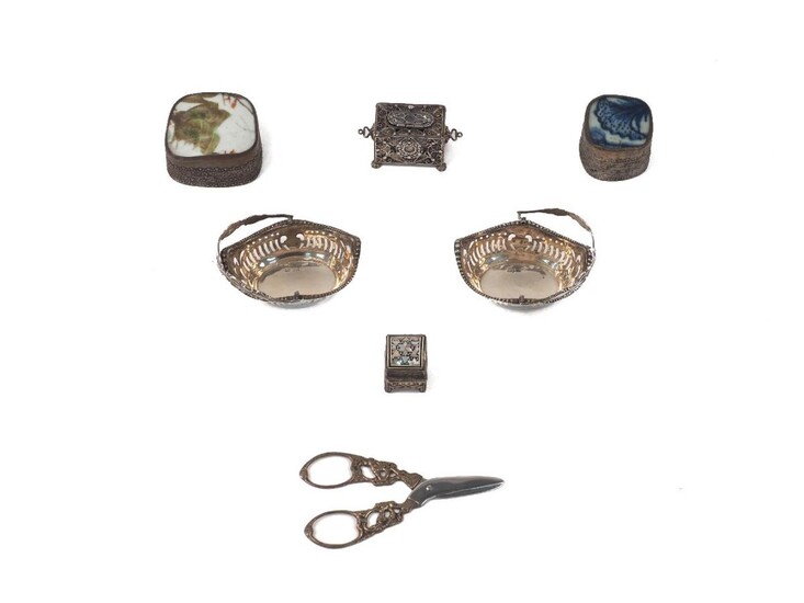A small collection of silver and white metal trinket boxes and oddments comprising: a pair of small silver bonbon dishes with swing handles, Birmingham, 1912, Henry Matthews; a mother-of pearl inlaid pill box, possibly Egyptian; a filigree trinket...