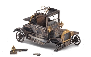 A white metal model of the Ford Model T car produced for the 65th anniversary of Ford Model T, engraved SOUVENIR DE J. PALAU 16.6.1973, 5.6cm high, 10.3cm wide, 5.3cm deep