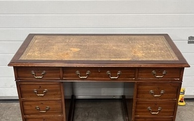 A writing desk, with a brown tooled leather writing surface,...