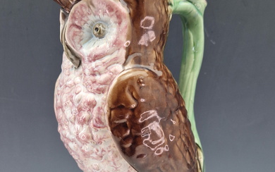 ATTRIBUTED TO GEORGE MORLEY & CO, A MAJOLICA OWL FORM JUG WITH A PINK FLOWER THUMBPIECE TO THE