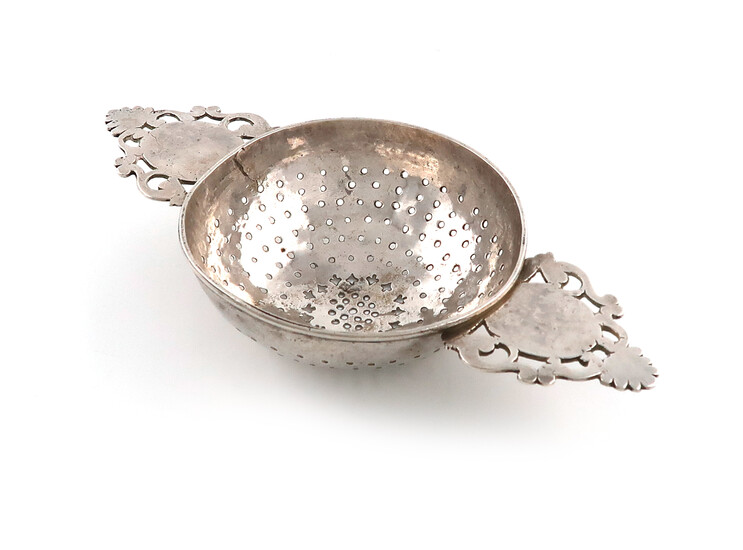 An early 18th century silver two-handled lemon strainer