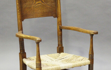 An early 20th century Arts and Crafts ash panel back elbow chair, designed by E.G. Punnet for Willia