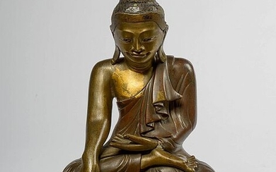 "Bouddha assis" en bronze à patine brune portant des traces de dorure et de laque. Travail birman. Epoque: XIXème. H.:+/-30cm.