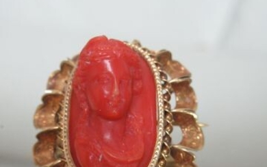 Broche en or jaune 18K, ornée d'un élément de corail sculpté, figurant un buste féminin....