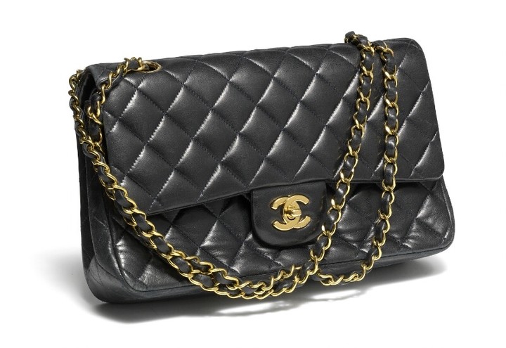 Chanel: A “Double Flap” bag of quilted black lampskin with double chain strap, golden hardware and one exterior and one interiour compartment with two pockets.