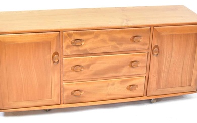 ERCOL; a light elm Windsor sideboard, with three drawers flanked...