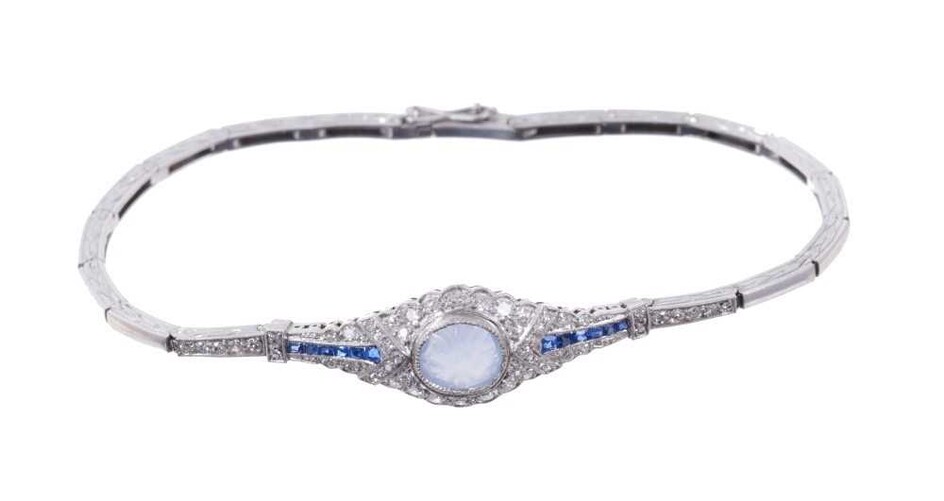 Edwardian style diamond and sapphire bracelet with a carved cabochon blue sapphire surrounded by single cut diamonds and flanked by calibre cut sapphires on an articulated and engraved white gold b...