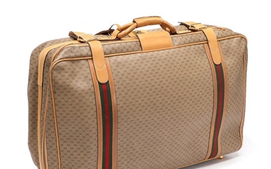 SOLD. Gucci: A suitcase made of brown monogram canvas and brown leather with gold toned...