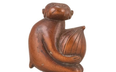 JAPANESE WOOD NETSUKE In the form of a monkey carrying a large chestnut. Height 2".