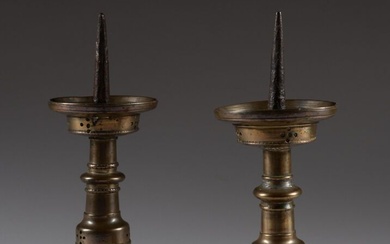 Paire de pique-cierges en bronze, fût à noeud aplati, décor de points repercés sur la...