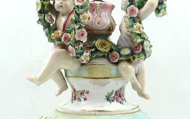 Pied de lampe balustre en porcelaine ornée de trois enfants dans des guirlandes de fleurs....