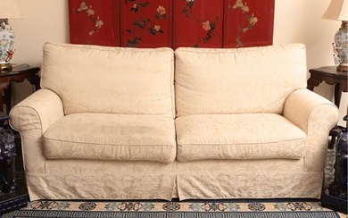 Upholstered sofa covered in ivory damask